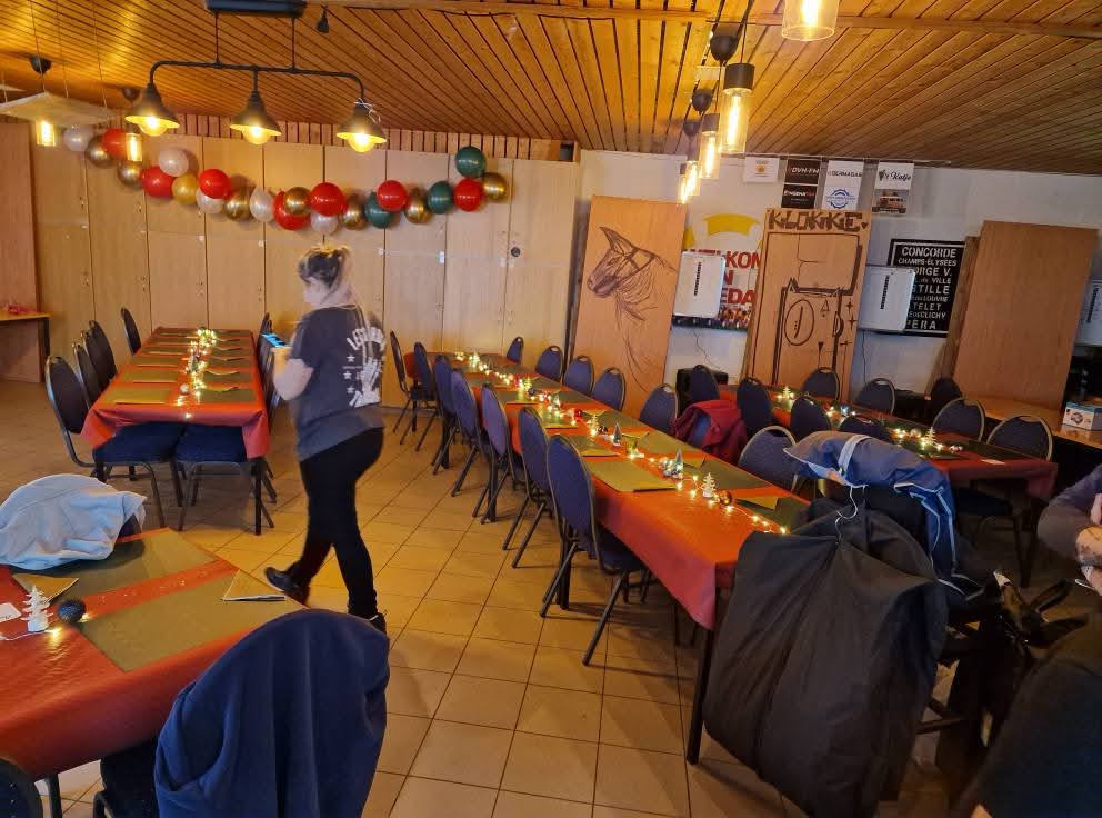 Lange feesttafels met lichtslingers en de toog van De Klokke