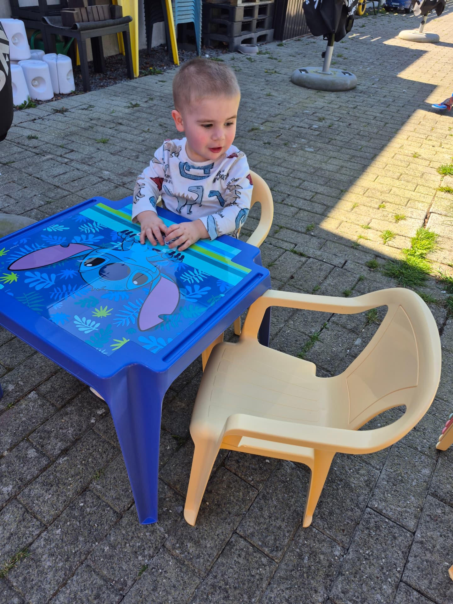 Kind aan een eigen tafeltje op het terras in de tuin
