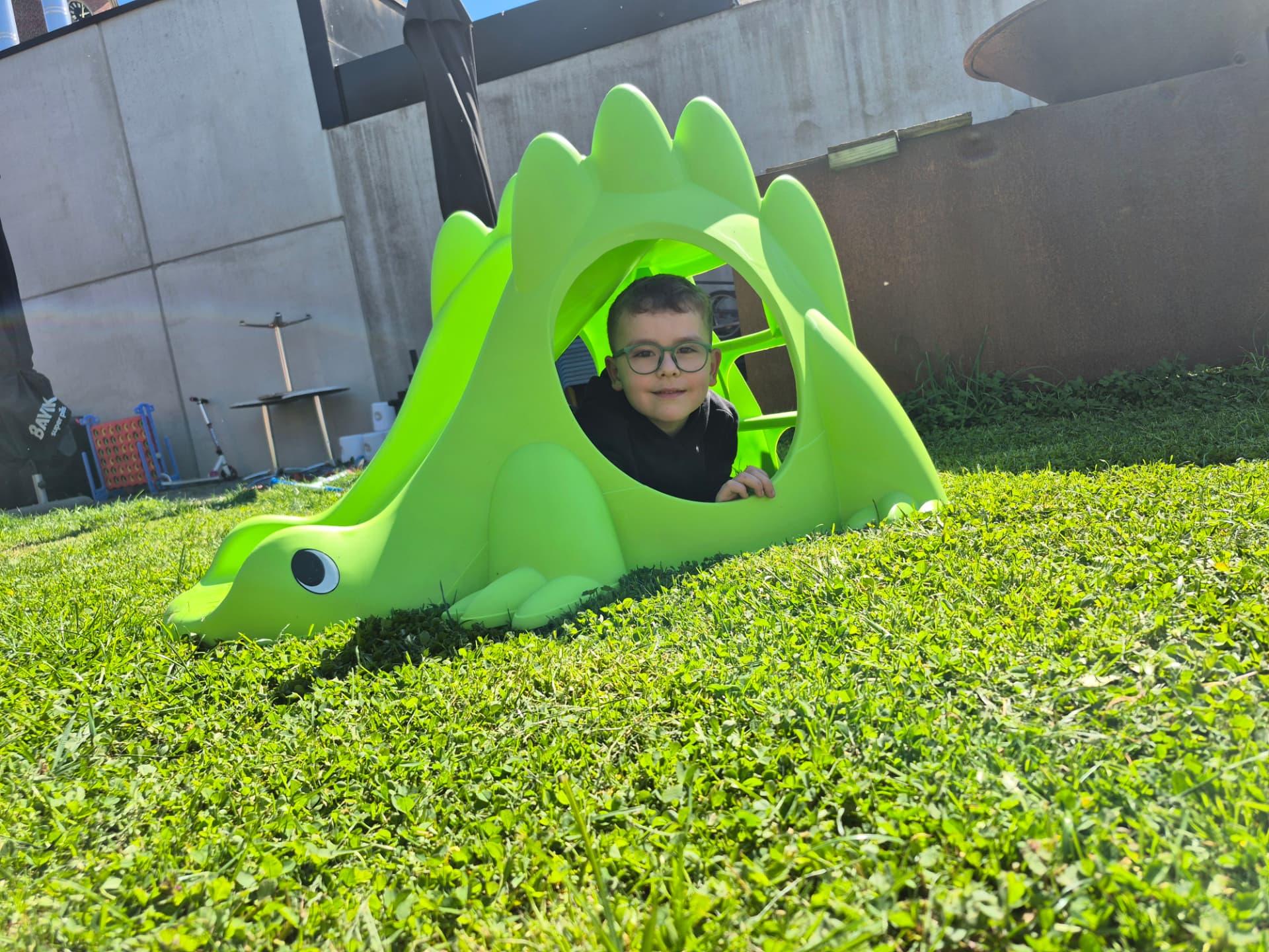 Kind speelt in het groene dino-speeltuig op het gras