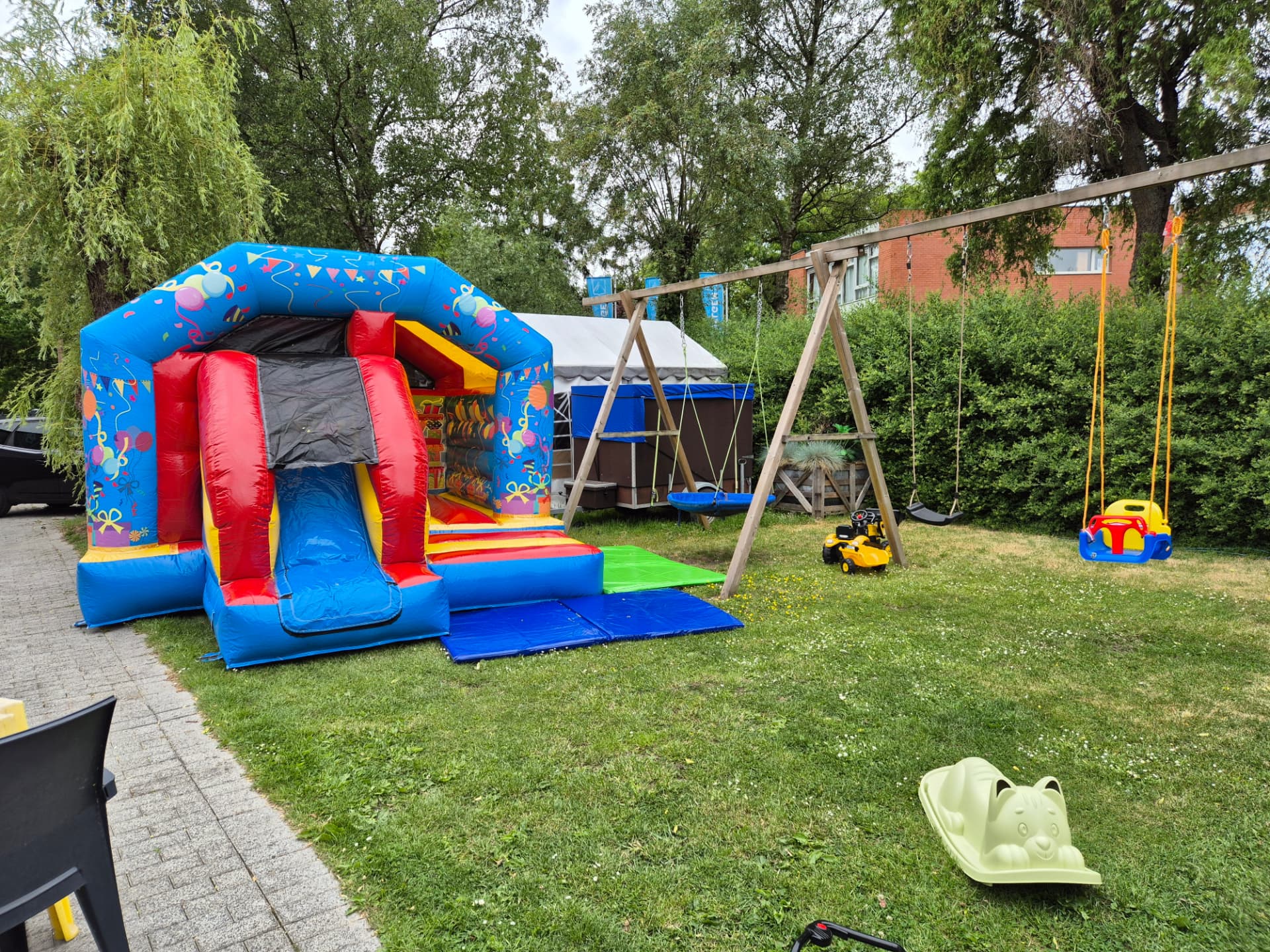 Springkasteel, schommels en speelgoed in de tuin