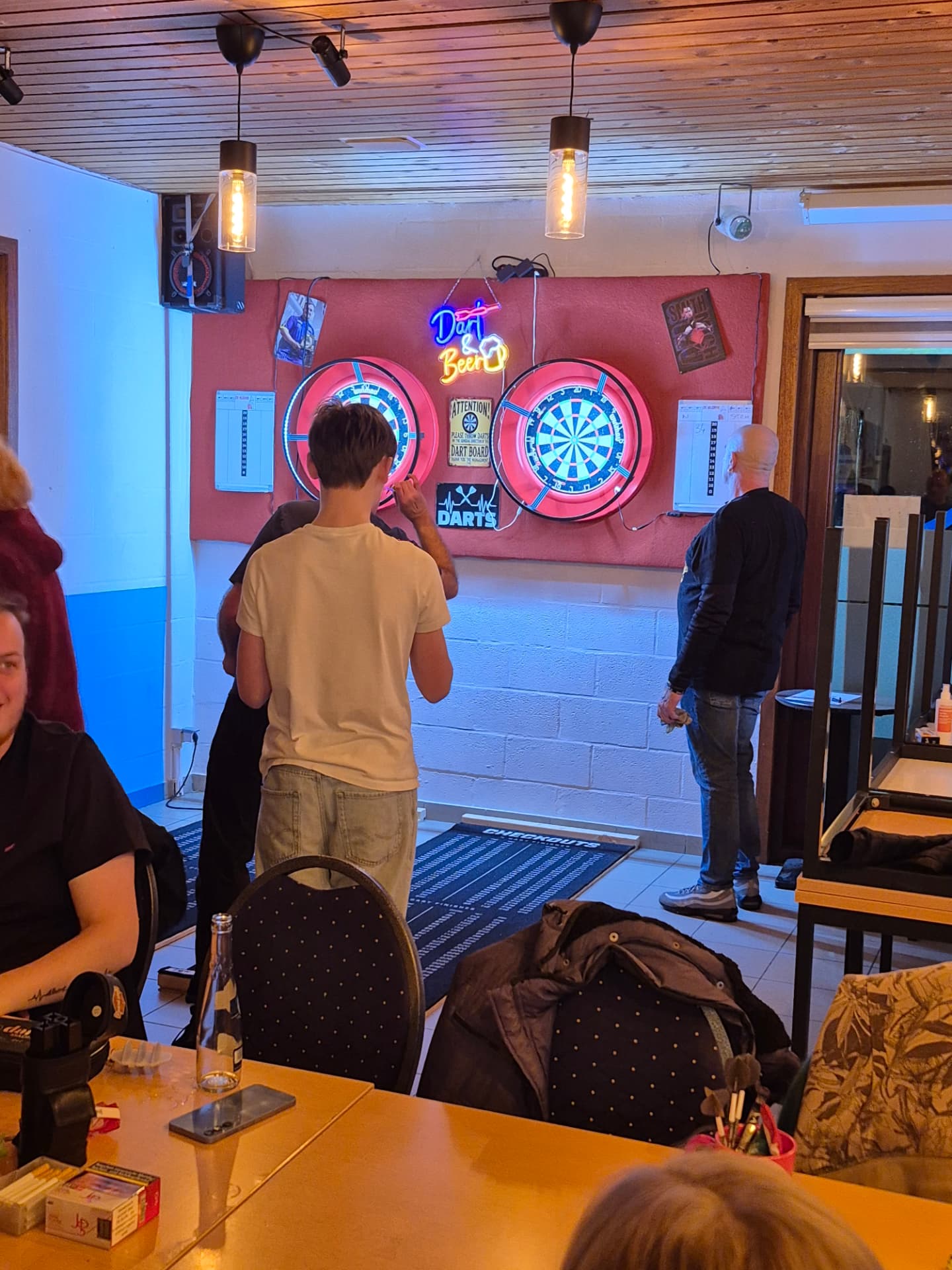 Speler aan de dartborden tijdens de dartsavond in het café
