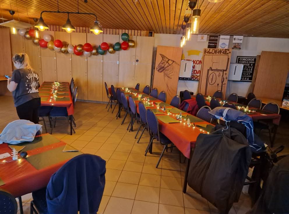 De zaal met gedekte tafels, ballonnenslinger en kerstversiering