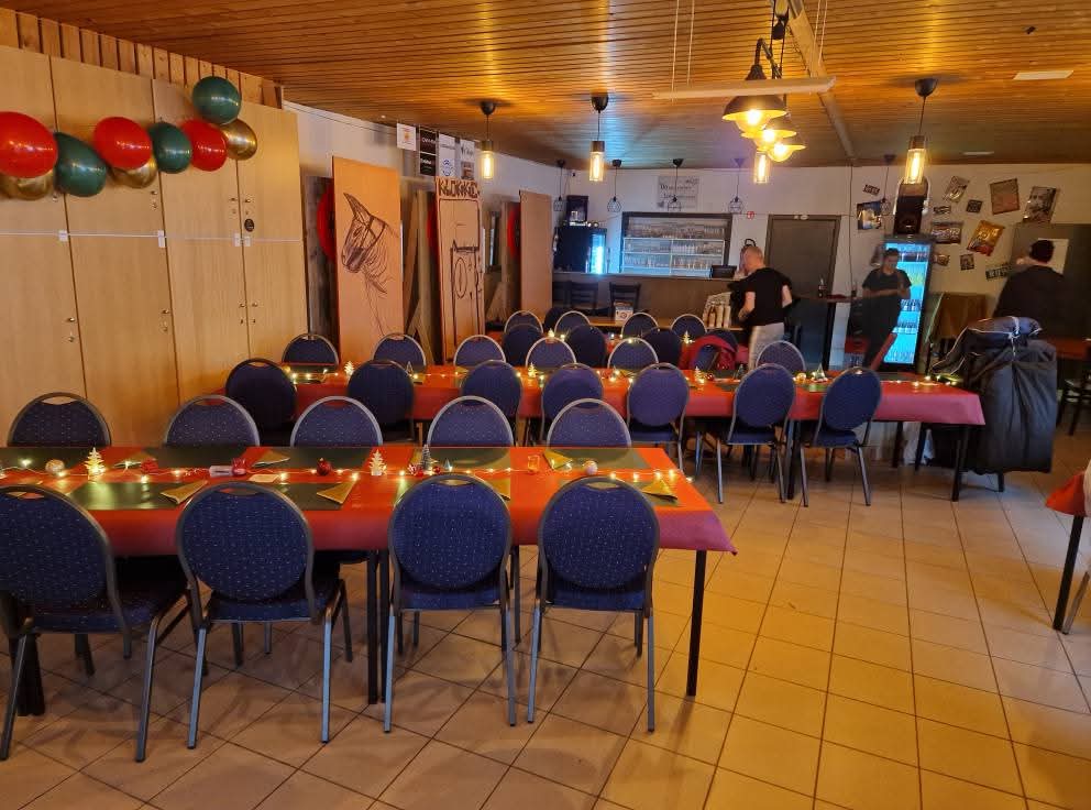 De zaal klaargezet met feesttafels en de toog op de achtergrond