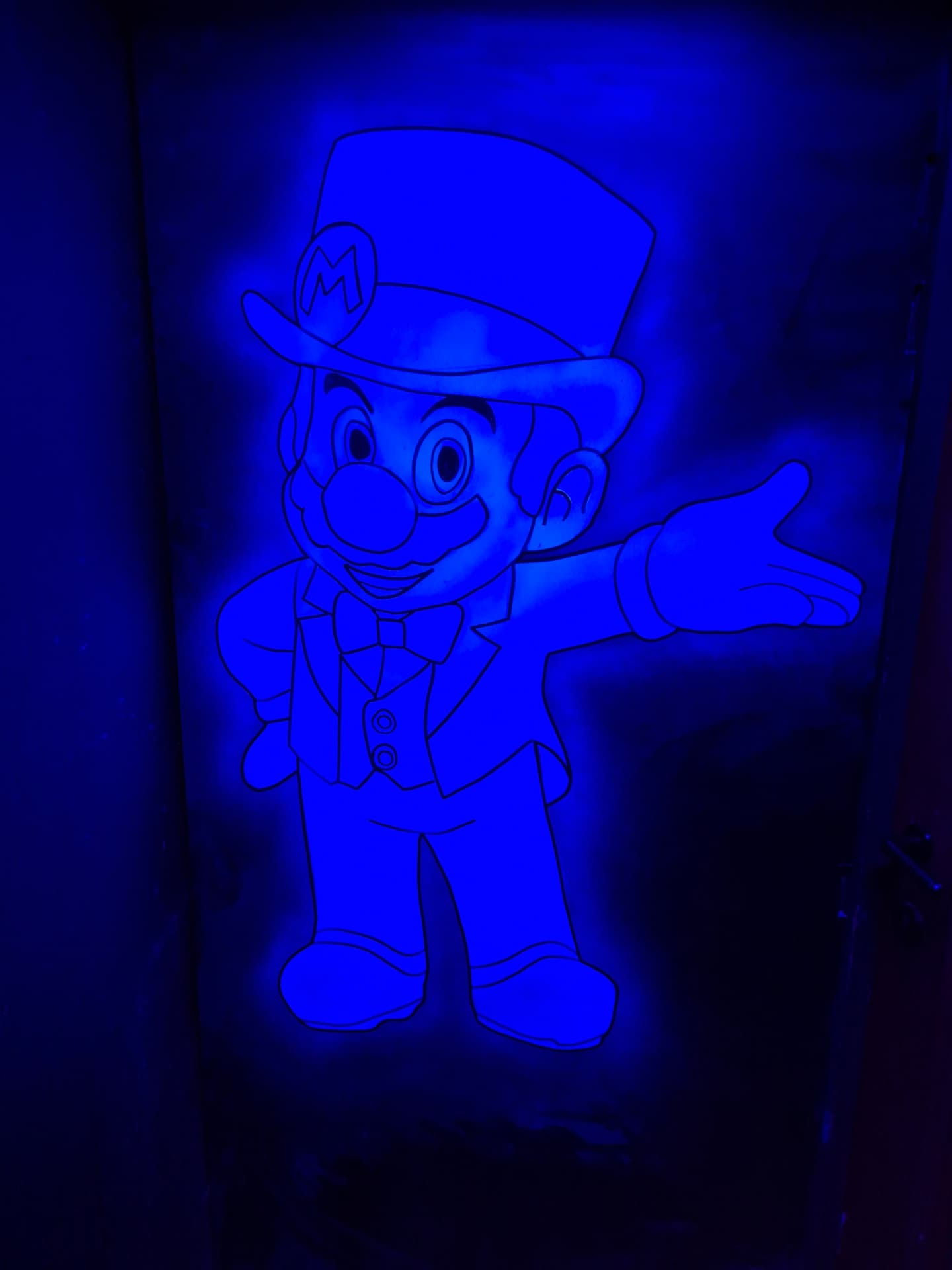Oplichtende Mario-tekening op de muur onder blauw licht