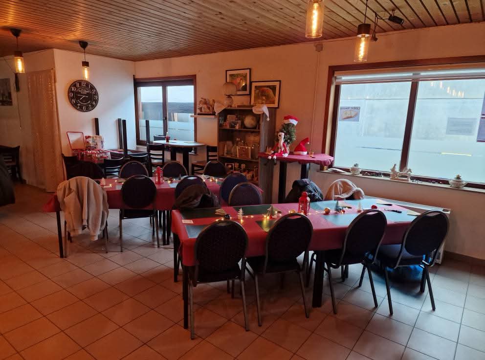 De kleinere zaalruimte met versierde tafels bij het raam